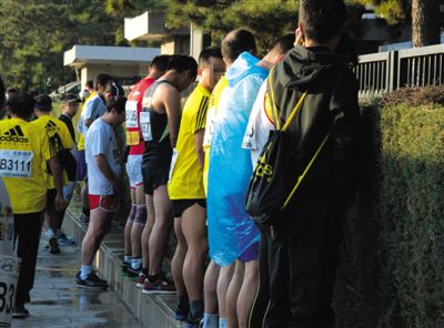 2013年10月20日，北京马拉松比赛，由于厕位有限，一些选手在绿化带“就地解决”。图/IC